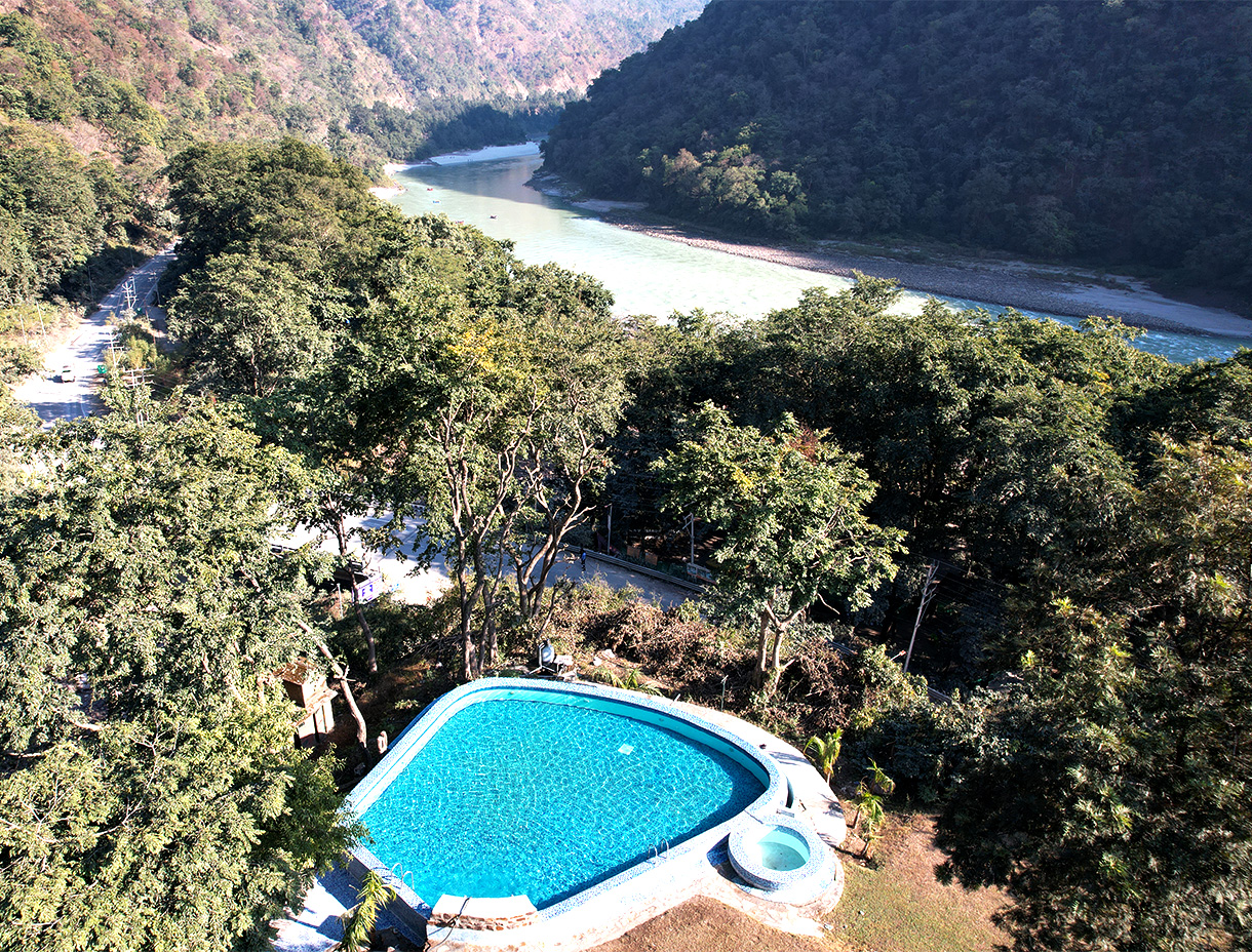 High Bank Himalayan Retreat above the Ganga with swimming pool and forested mountains